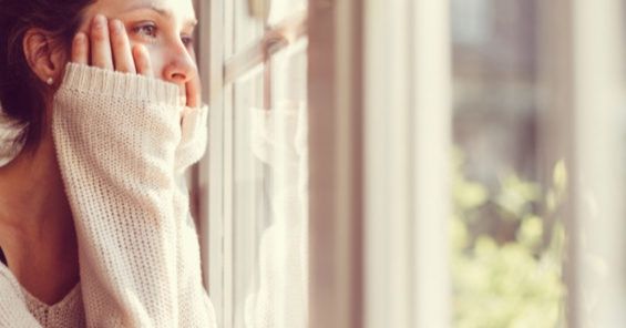 Woman looking thru window - Depression and the Warning Signs of Suicide